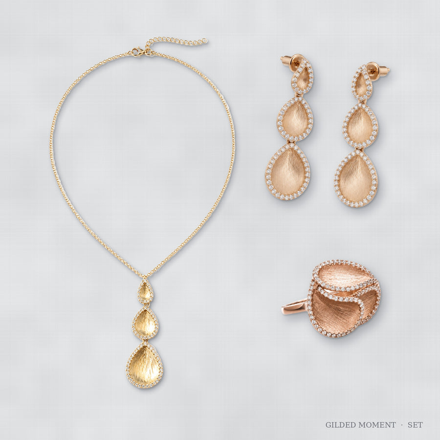 Gilded Moment jewelry set flat lay – ring, earrings and necklace arranged together