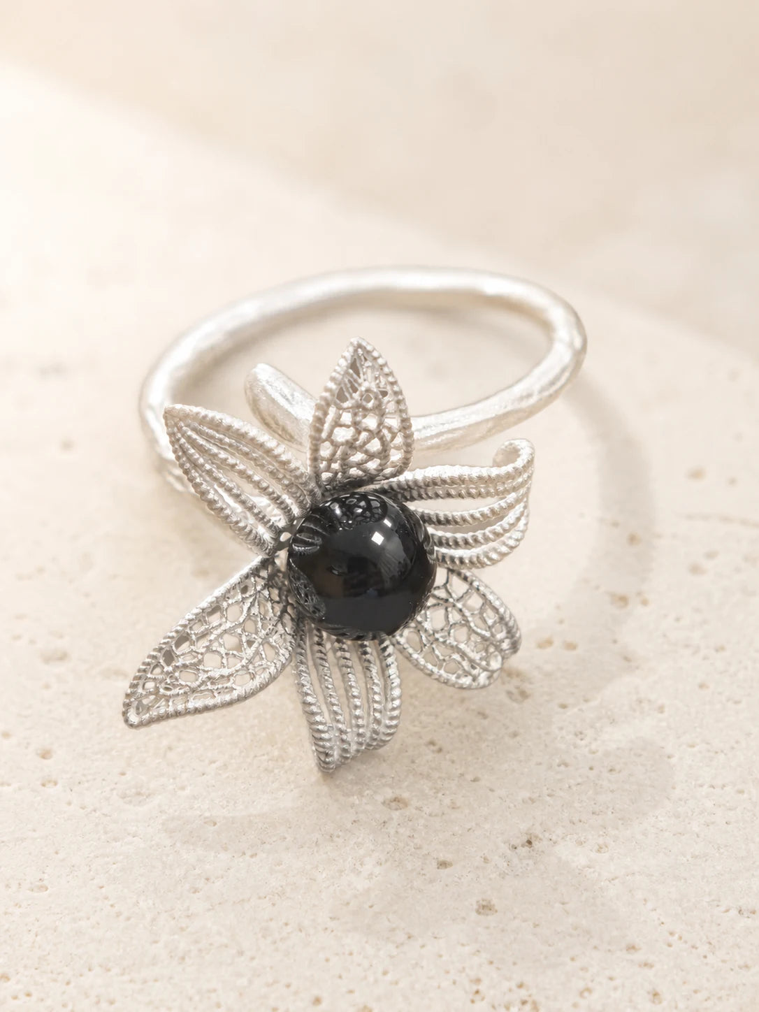 Noir Bloom floral ring with dark center stone