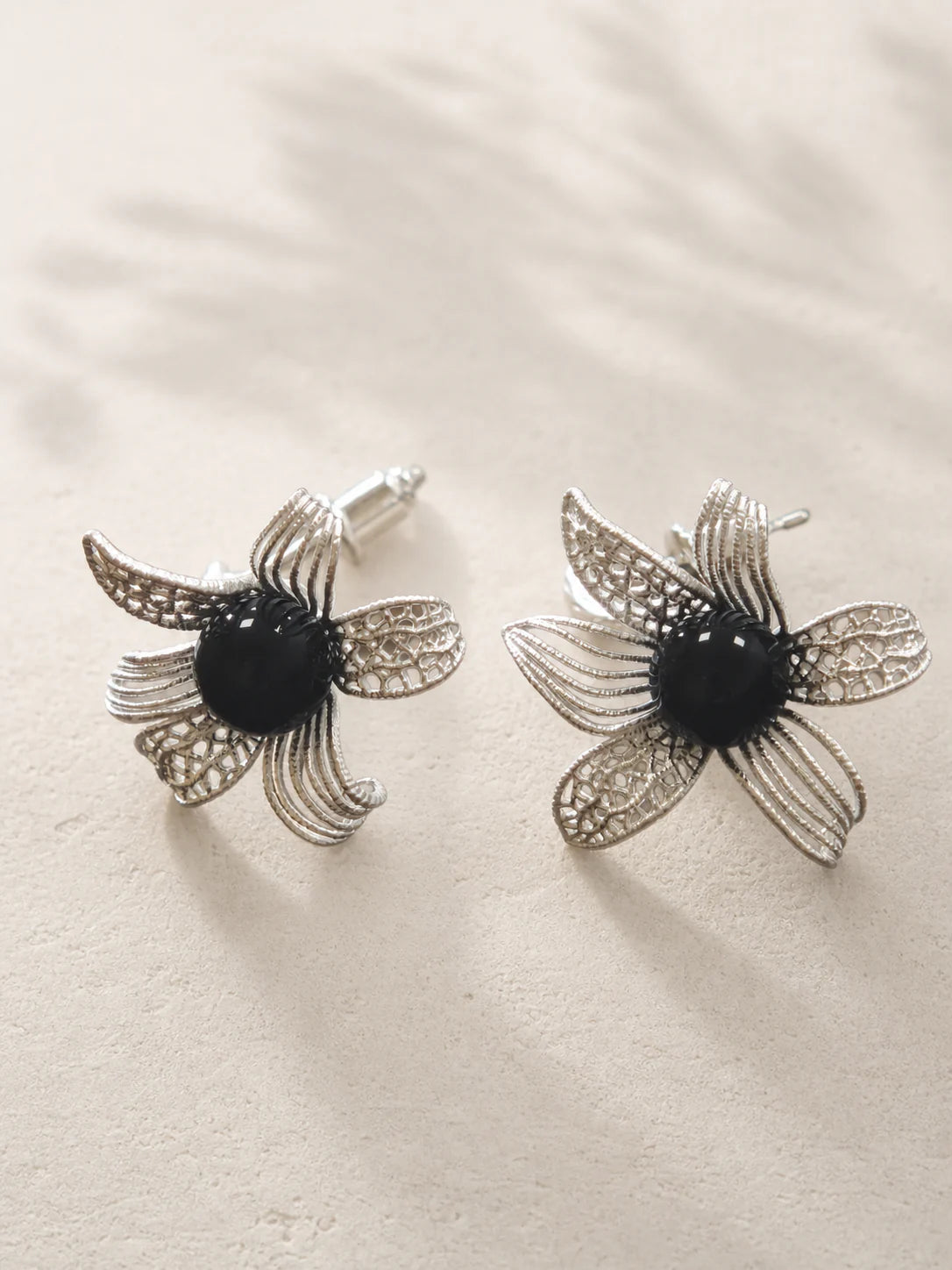 Noir Bloom floral earrings with dark center stones