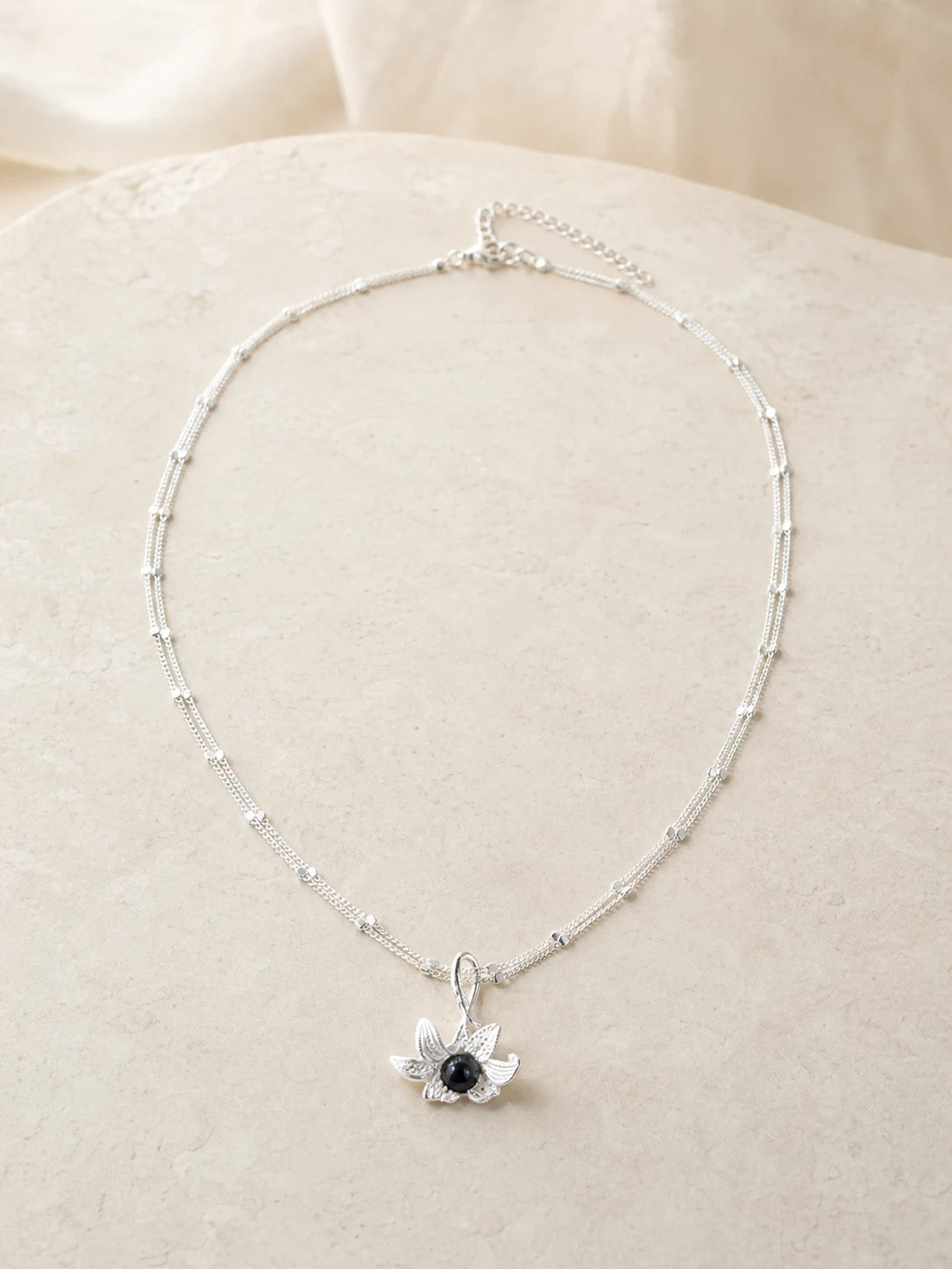 Noir Bloom floral necklace with dark center stone